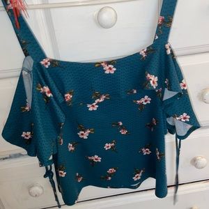 It’s a tank top and fits like a crop top. It has floral designs!